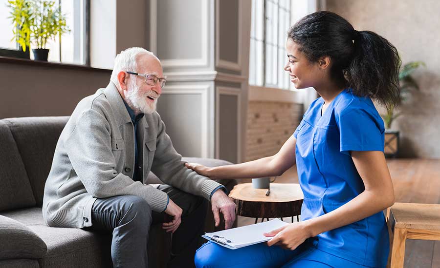 A professional caregiver visits an elderly man in his home