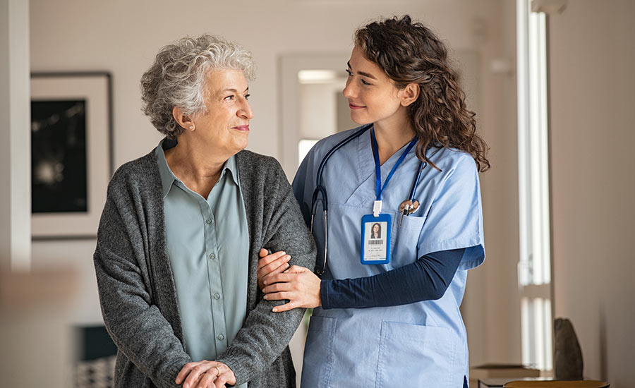 A professional caregiver is visiting an old woman in her home​