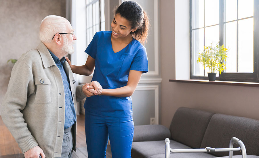 An elderly man being assisted by a caregiver​